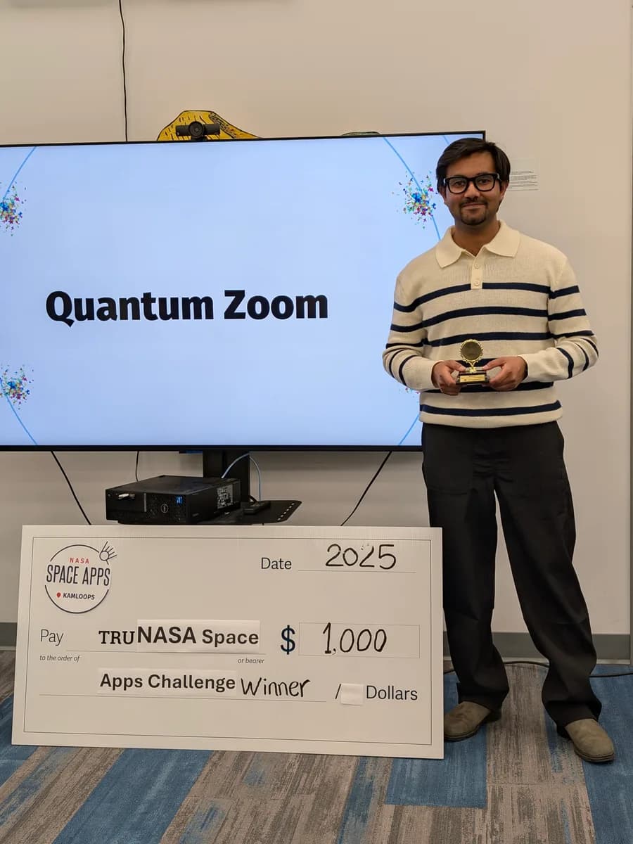 Ashu Sharma holding the winner’s trophy beside a $1,000 NASA Space Apps Challenge cheque, with the Quantum Zoom project on the screen behind